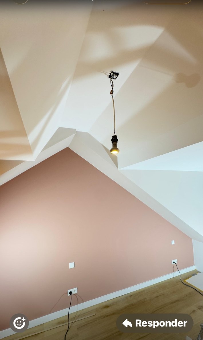 Woonkamer met geschilderde accentwand en strak afgewerkte witte plafondlijnen